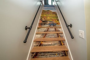 A staircase with a unique design featuring a railway track pattern on the steps.