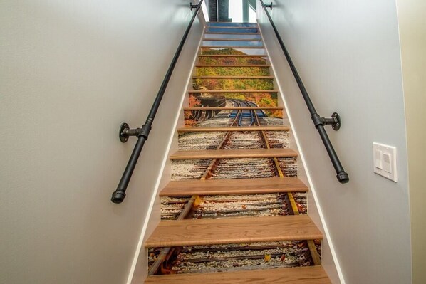 A staircase with a unique design featuring a railway track pattern on the steps.