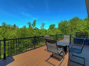 A deck with outdoor furniture, a table, and chairs.