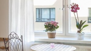 A cozy room with a round table, a chair, and a window with curtains. - Cosy Quiet Apartment Close to the Sea and Parks (Helsinki)