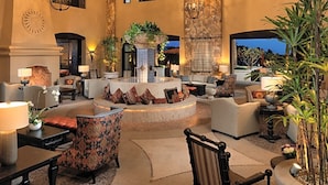 A spacious lobby with a central fountain, comfortable seating, and a large window providing a view of the outdoors. - Sweeping ocean view Luxury Penthouse 2 Bedrooms (Cabo San Lucas)