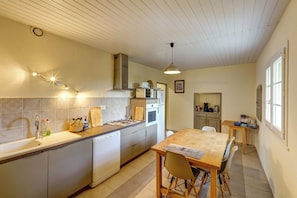 A kitchen with a wooden table, a sink, and a stove. - Mas Provence Gardoise ( Uzès) - swimming pool 12-6 m - 9 acres garden (Tresques)