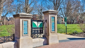 Un panneau indiquant l’entrée du parc, sur lequel on peut lire « Washington Park », entouré de piliers en pierre et d’une grille en métal.