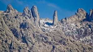 Een ruig berglandschap met opvallende rotsformaties en schaarse begroeiing.