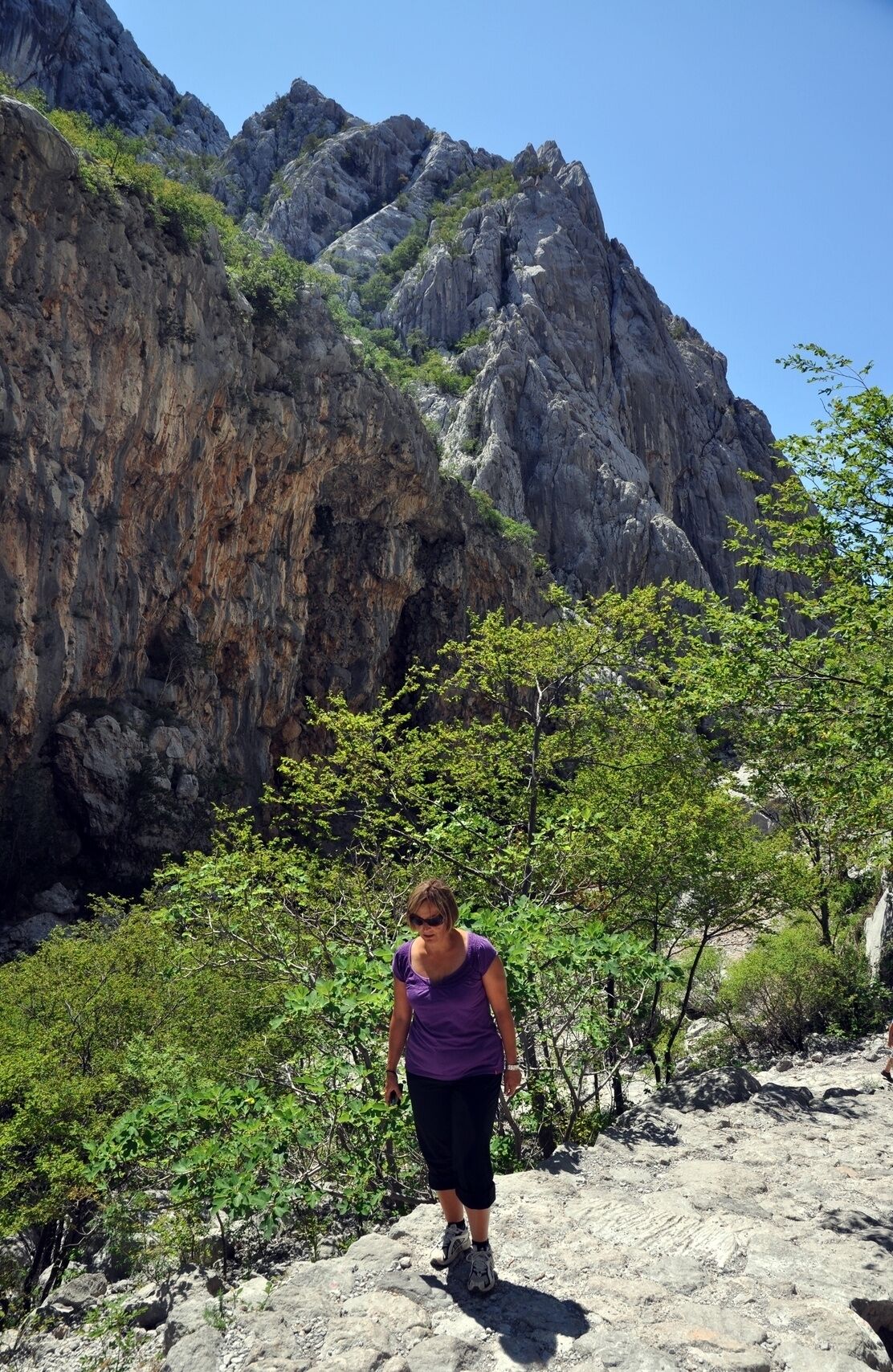 A rocky hiking trail with a person walking.