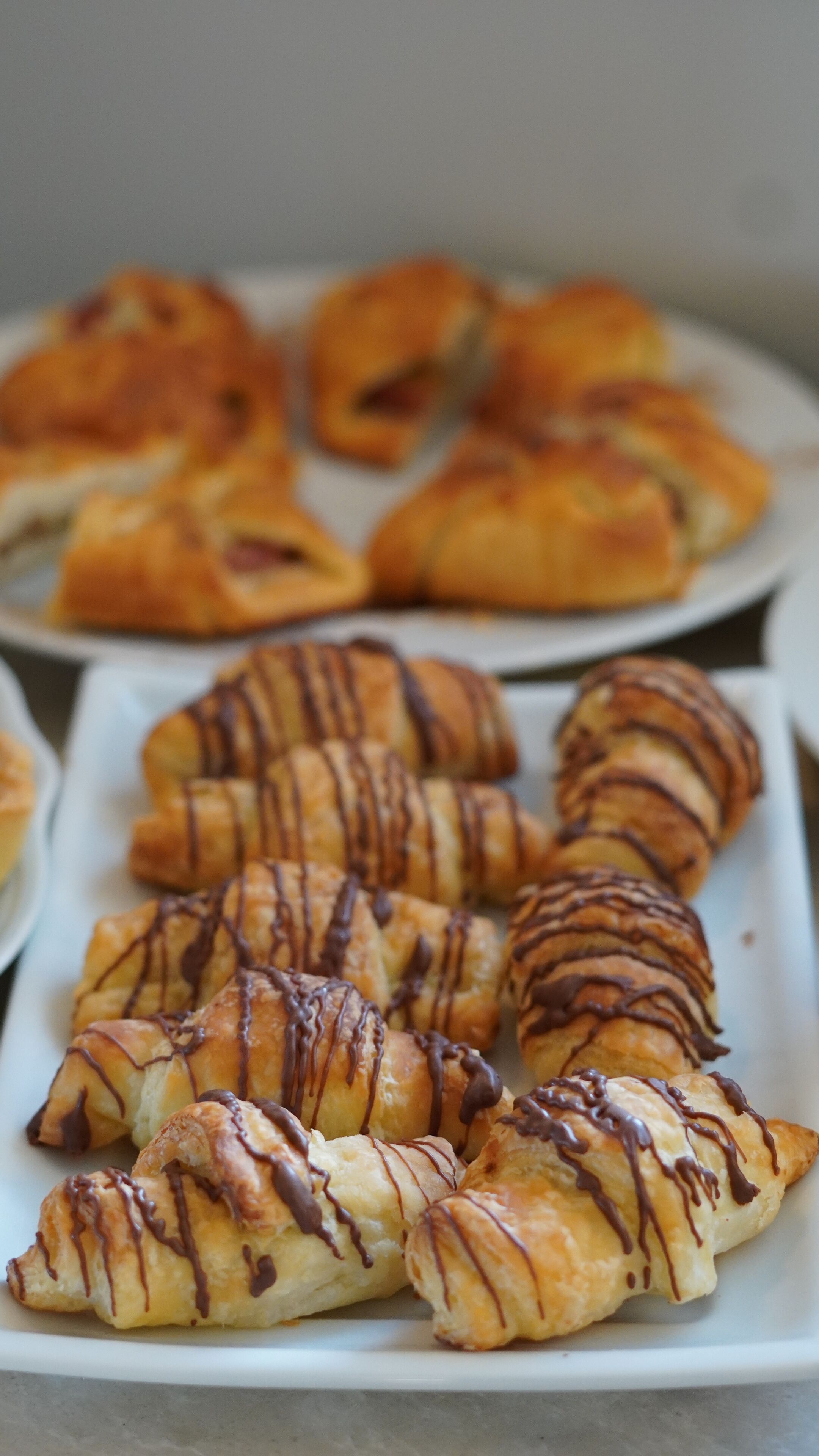 A plate of pastries with chocolate drizzle.