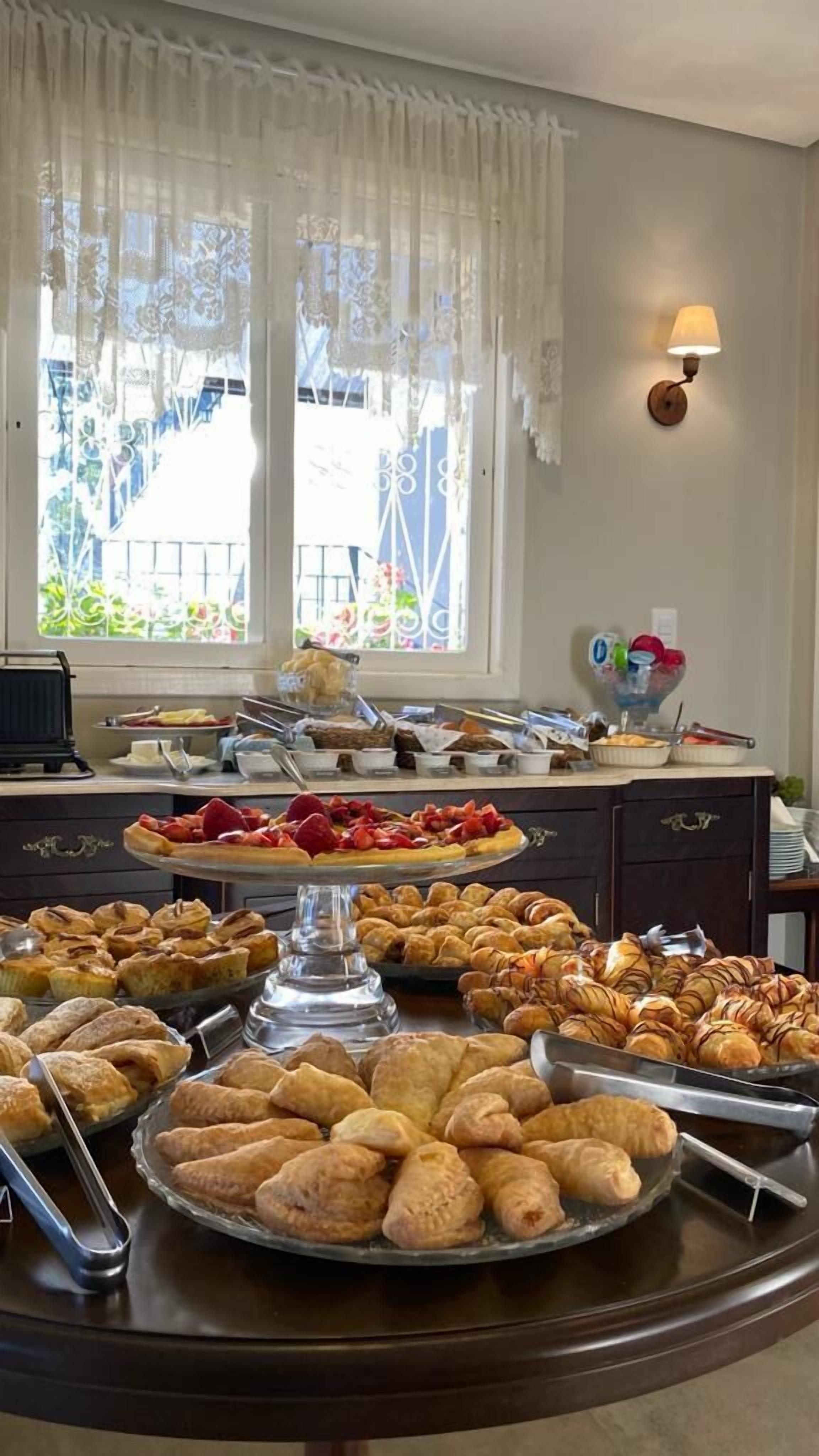 Una mesa de buffet con diversos pasteles y una máquina de café.