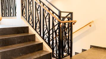 A staircase with black metal railings and wooden handrails.