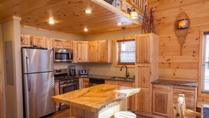 A wooden cabin-style kitchen with a central island, stainless steel appliances, and a wooden ceiling. - Beautiful ADK Getaway! Trail 4 and Lake Access!  Weekly Discount Available (Old Forge)