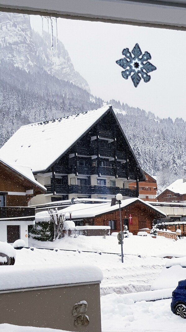A snow-covered mountain village with wooden buildings and a prominent ski lift.