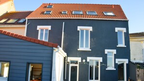 A two-story building with a dark facade, red-tiled roof, and multiple windows. - Wimereux: Large house ideally located 🏖, Les Arômes (Wimereux)