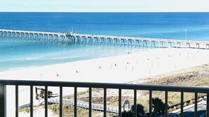 A beach with a pier extending into the ocean, a clear sky, and a road leading to the beach. - FALL DEALS! CALYPSO 3-1004 FREE BEACHSETUPS! Romantic Ocean View from KING Bed! (Panama City Beach)