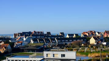 Een kustwoongebied met huizen, een klein waterlichaam en een modern gebouw met een plat dak.