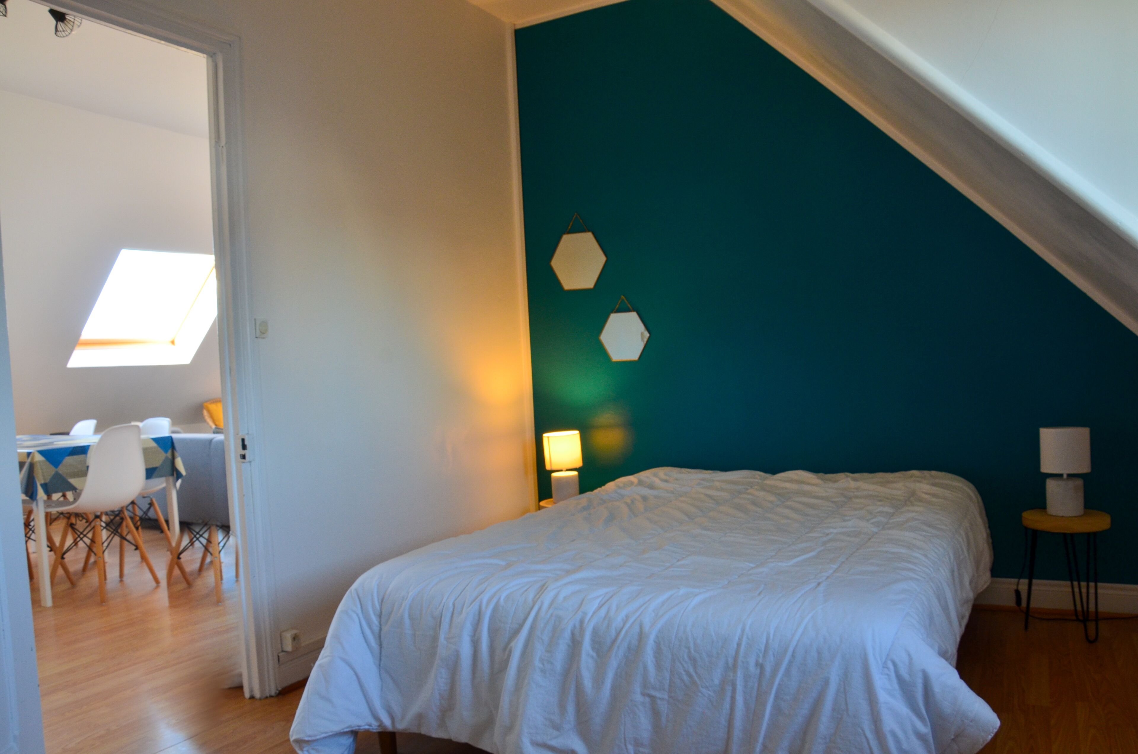 A bedroom with a bed, a desk, and a chair.