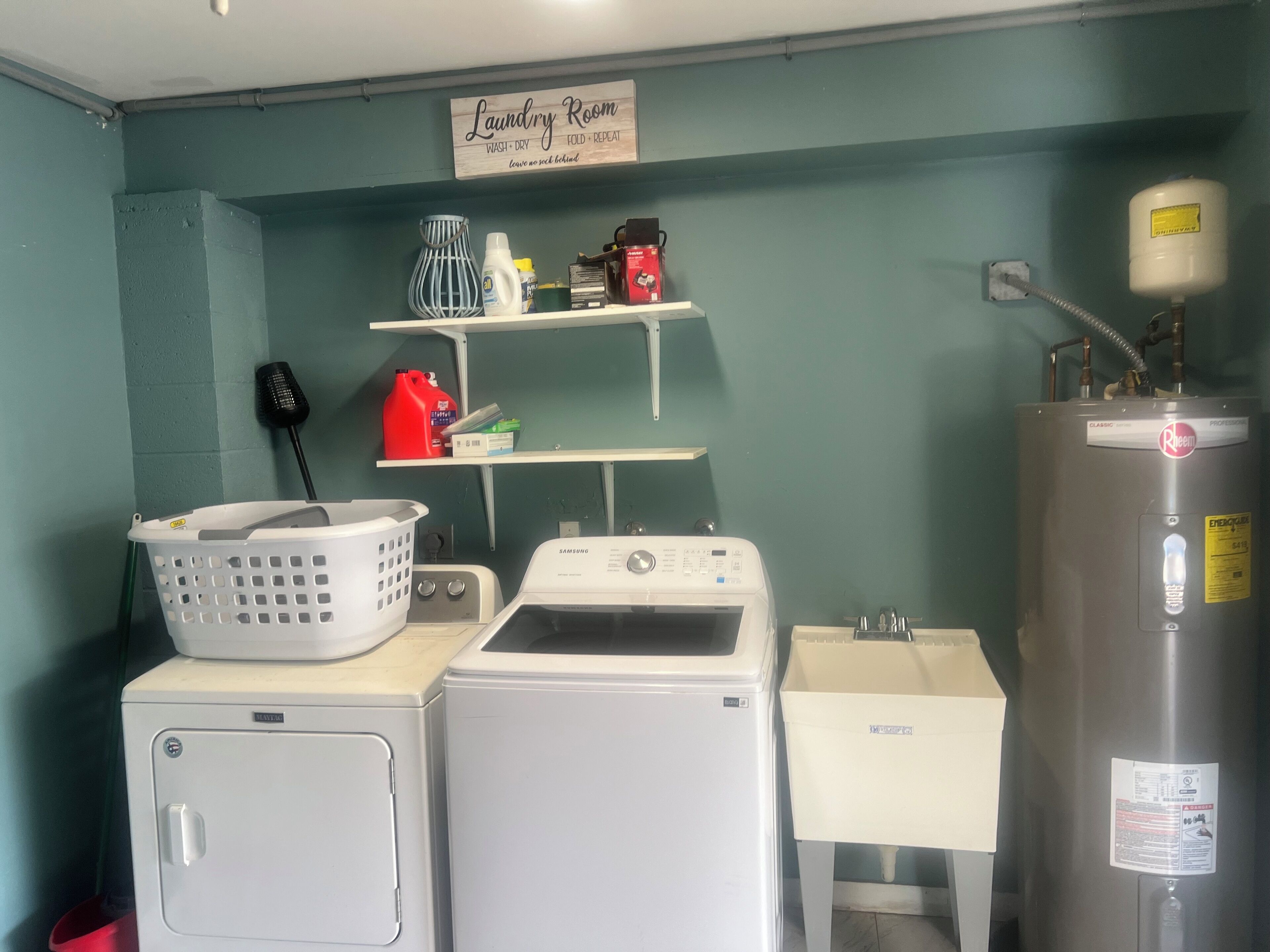 A laundry room with a washing machine, dryer, and a water heater.