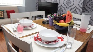 Uma mesa de jantar posta com pratos, tigelas e uma fruteira.