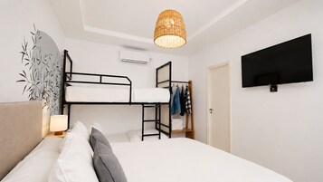 Habitación con literas, televisión, lámpara y armario.