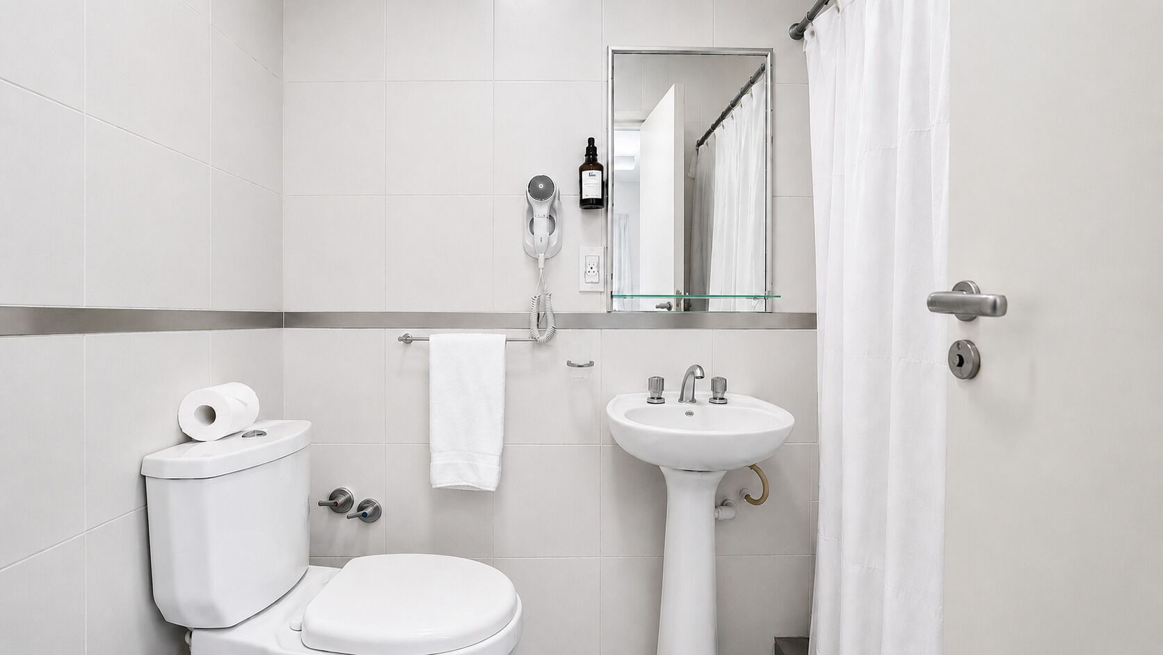 A modern bathroom with a toilet, sink, and shower curtain.