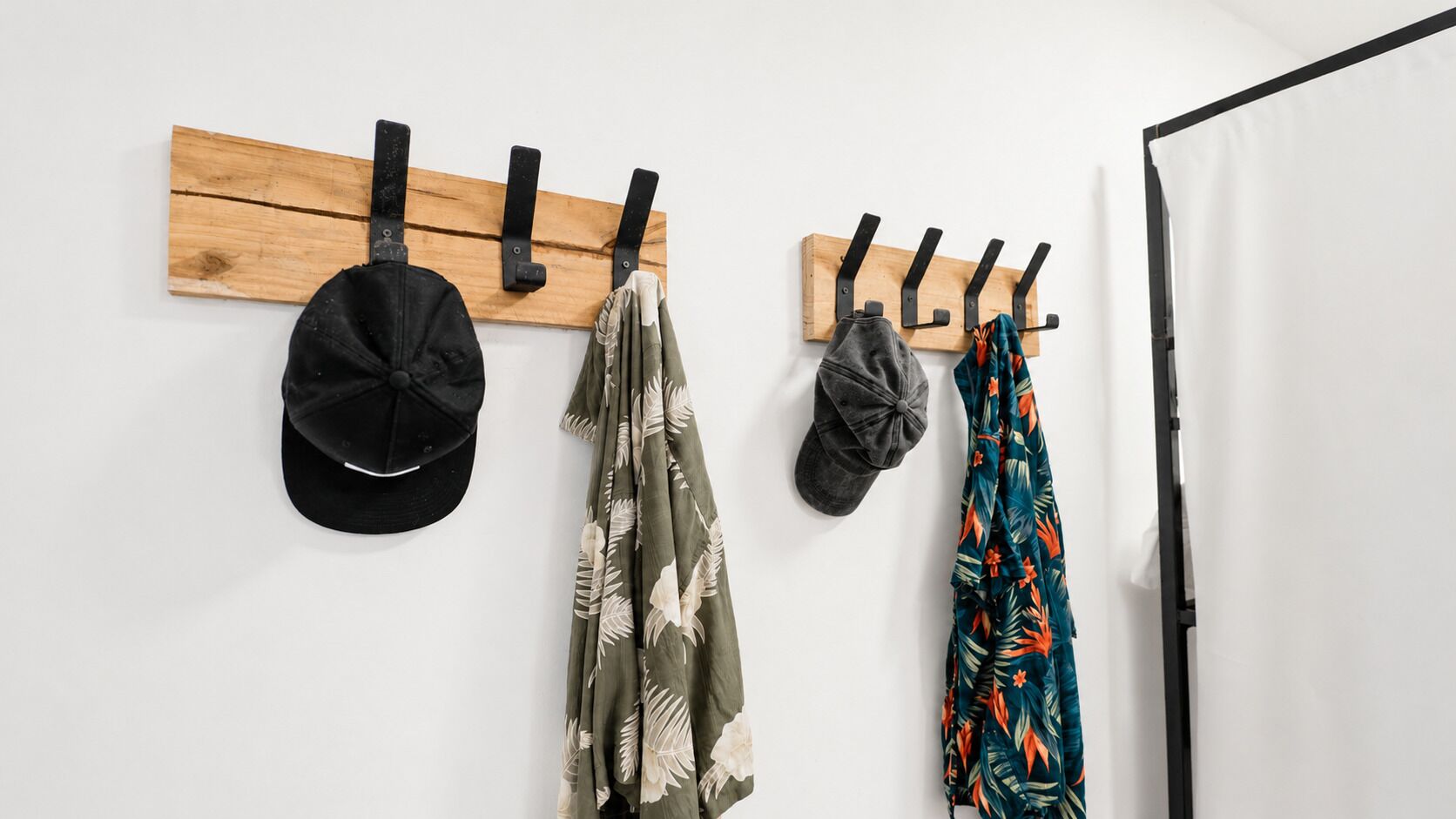 A wall-mounted coat rack with four hats and a jacket.