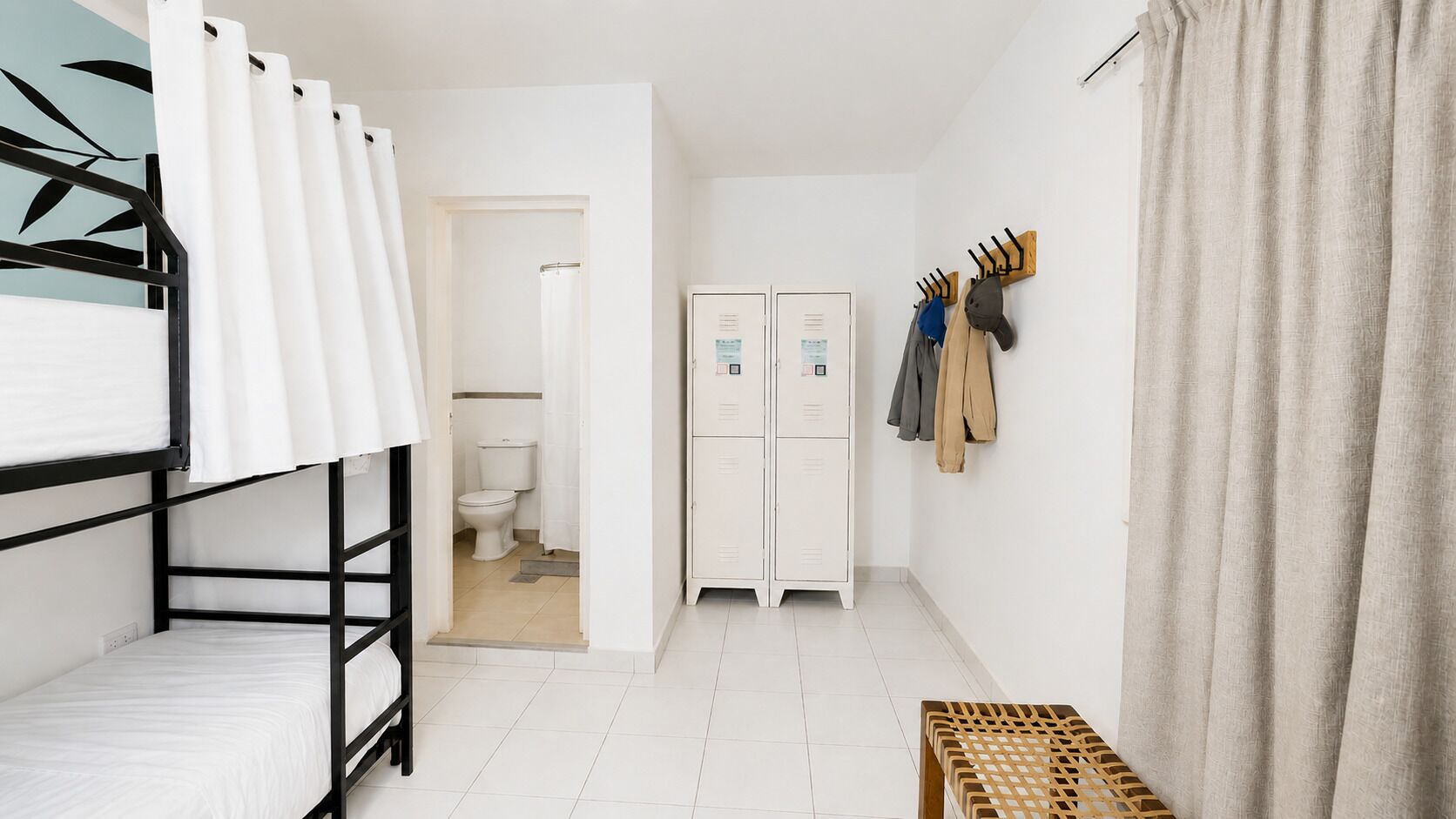 Une chambre avec un lit superposé, des toilettes blanches et une armoire.