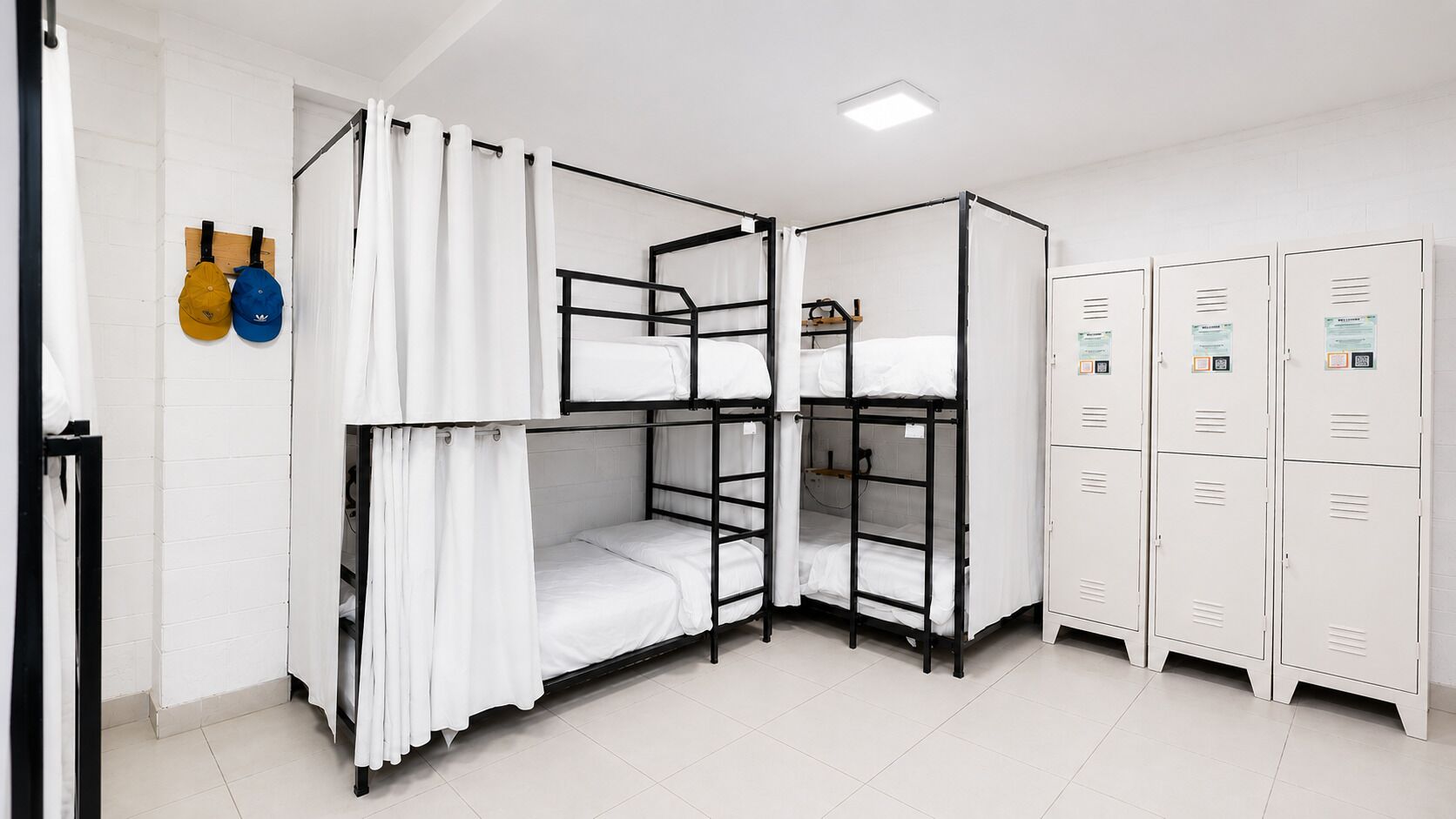 A bunk room with two bunk beds, white curtains, and a set of white lockers.