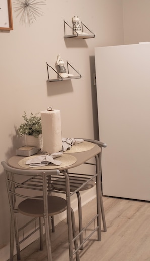 A small dining area with a round table, two chairs, a potted plant, and a towel. - Remodeled historical loft walking distance from the Square. (Holly Springs)