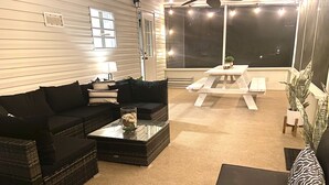 Un salon chaleureux avec un canapé d’angle, une table basse et une petite table sur laquelle est posée une plante.