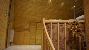 A wooden interior with a staircase, a radiator, and a floral arrangement.