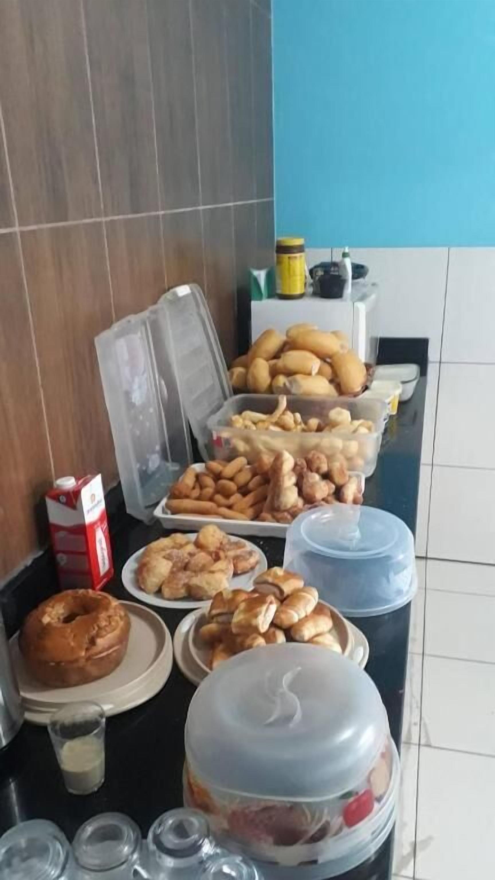 Een buffettafel met diverse gerechten, waaronder gebak, een donut en een schaal fruit.