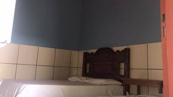 Una habitación con dos camas, piso de baldosas y techo decorado.