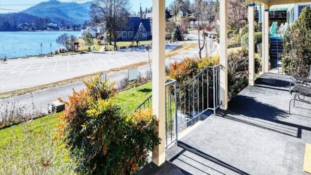Un espacio al aire libre techado con vista a un lago y montañas.