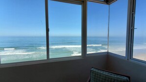 Una habitación con un amplio ventanal con vista al océano.