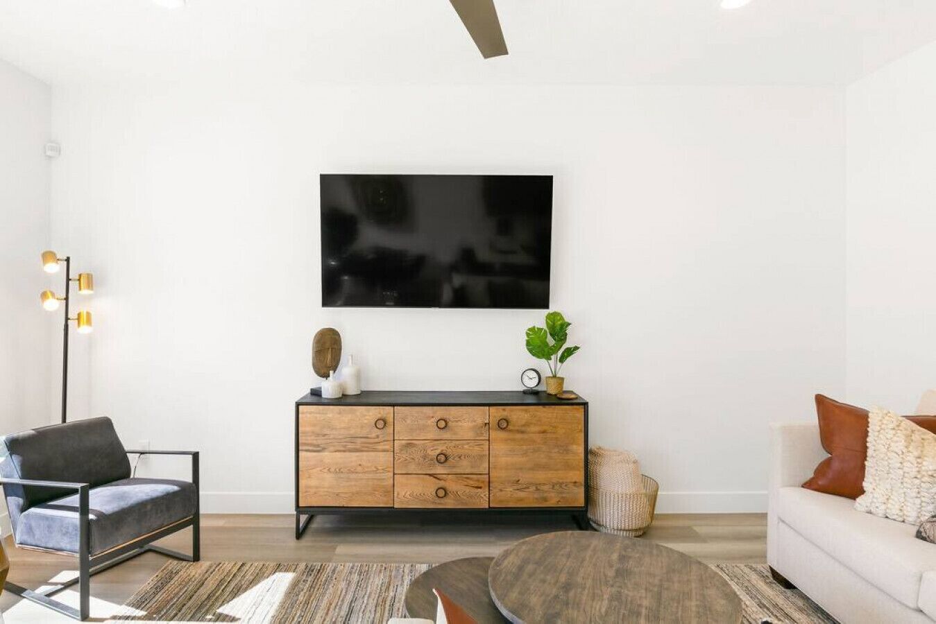 A modern living room with a wooden cabinet, a black TV, and a sofa.