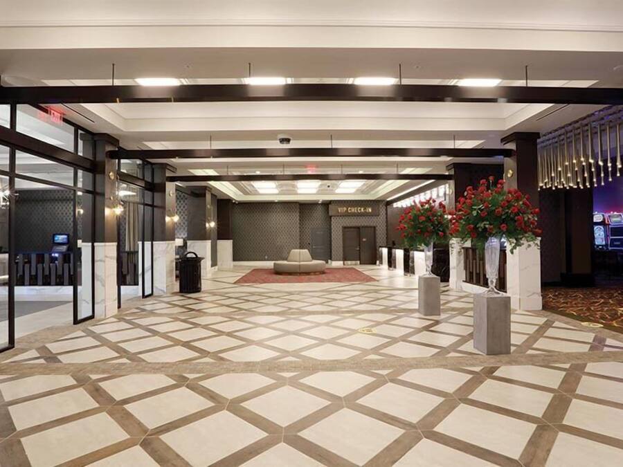 Un hall d’entrée spacieux comprenant un comptoir d’enregistrement, un espace salon et un sol à motifs.