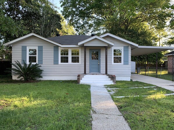 A single-story house with a front porch, a mailbox, and a small front yard.