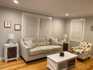 A living room with a sofa, a coffee table, and two side tables.
