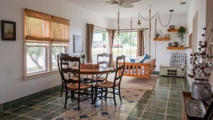 A dining area with a table and chairs, a hanging light fixture, and a ceiling fan.
