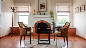 A living room with a fireplace, two armchairs, a coffee table, and a floor lamp.