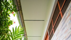A corridor with a tiled floor, stone walls, and wooden doors. - HOSPEDAJE SANTA MONICA (Tarapoto)