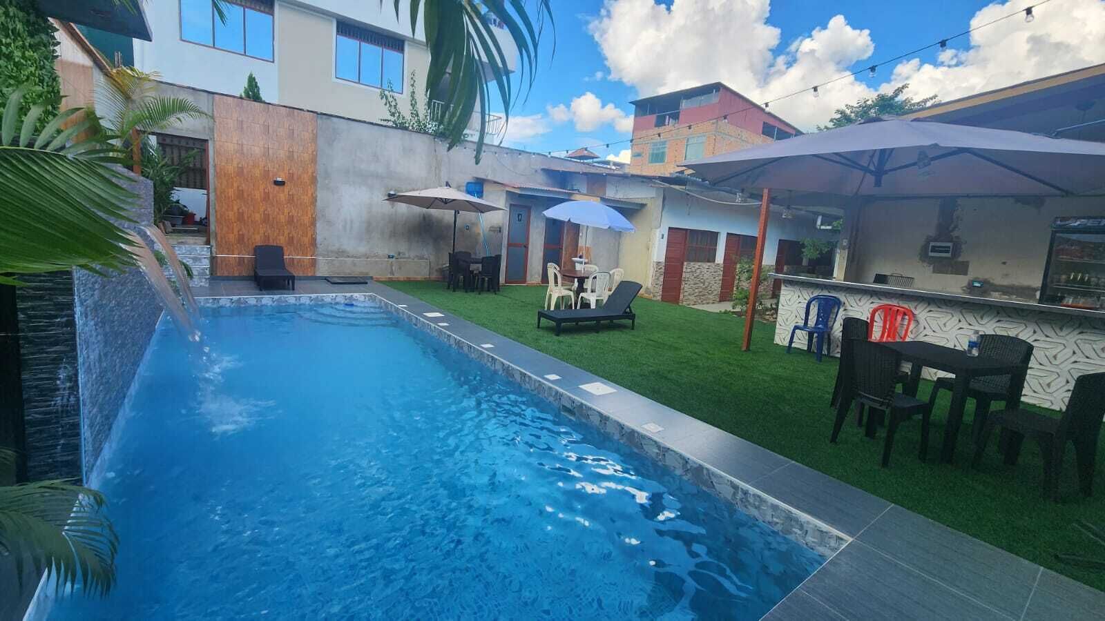 A swimming pool with a patio area, including a bar and outdoor seating.
