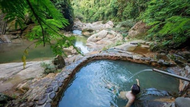 A natural hot spring surrounded by rocks and greenery. - HOSPEDAJE SANTA MONICA (Tarapoto)