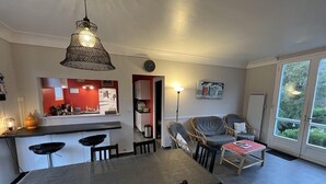 A modern kitchen with a dining area, a large window, and a view of greenery outside. - 032 - 3 *** villa in a quiet area close to the beaches and the city center (SOULAC SUR MER)