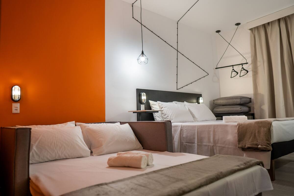 Ein Hotelzimmer mit zwei Betten, einem Nachttisch, einer Wandlampe und einer Pendelleuchte.