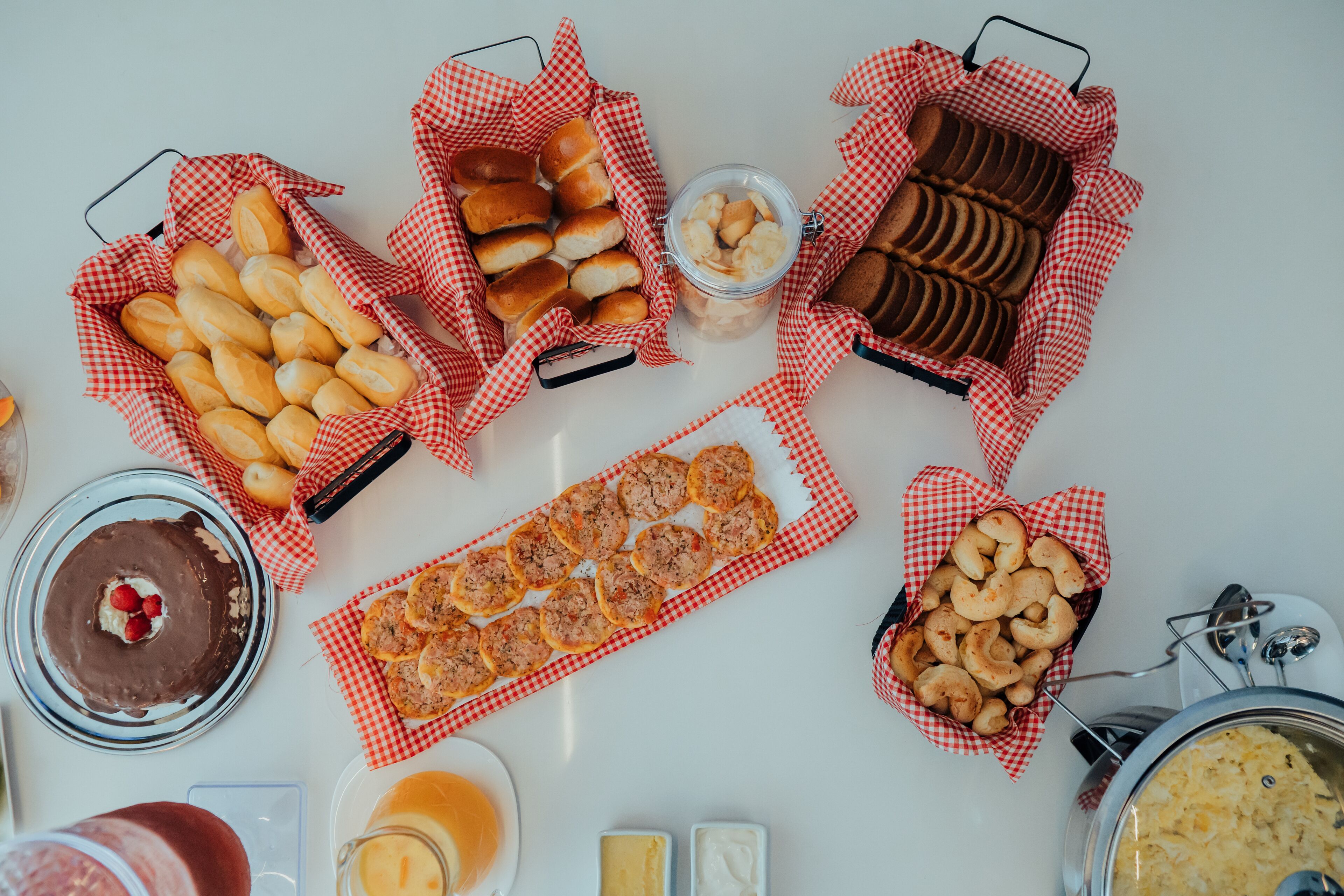 Une table où sont présentés divers aliments, notamment du pain, des pâtisseries et un dessert au chocolat.