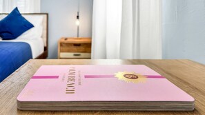 Un carnet rose intitulé « Guide nocturne de la Floride » est posé sur une table en bois dans une chambre d’hôtel.