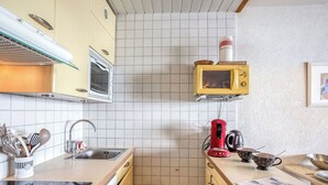 Mikrobølgeovn, oppvaskmaskin og høy barnestol