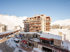 A multi-story hotel with balconies, a restaurant, and a view of snow-covered mountains. - Lovely apartment for 2 people with WIFI, TV and balcony (Les Boisses)