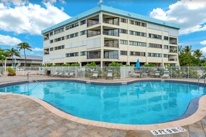 A hotel with a pool, a white fence, and a blue sky. - Luxury Condo at Ocean Front Kawama Tower Complex (Key Largo)