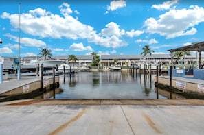 A marina with boats docked, palm trees, and a clear sky. - Luxury Condo at Ocean Front Kawama Tower Complex (Key Largo)