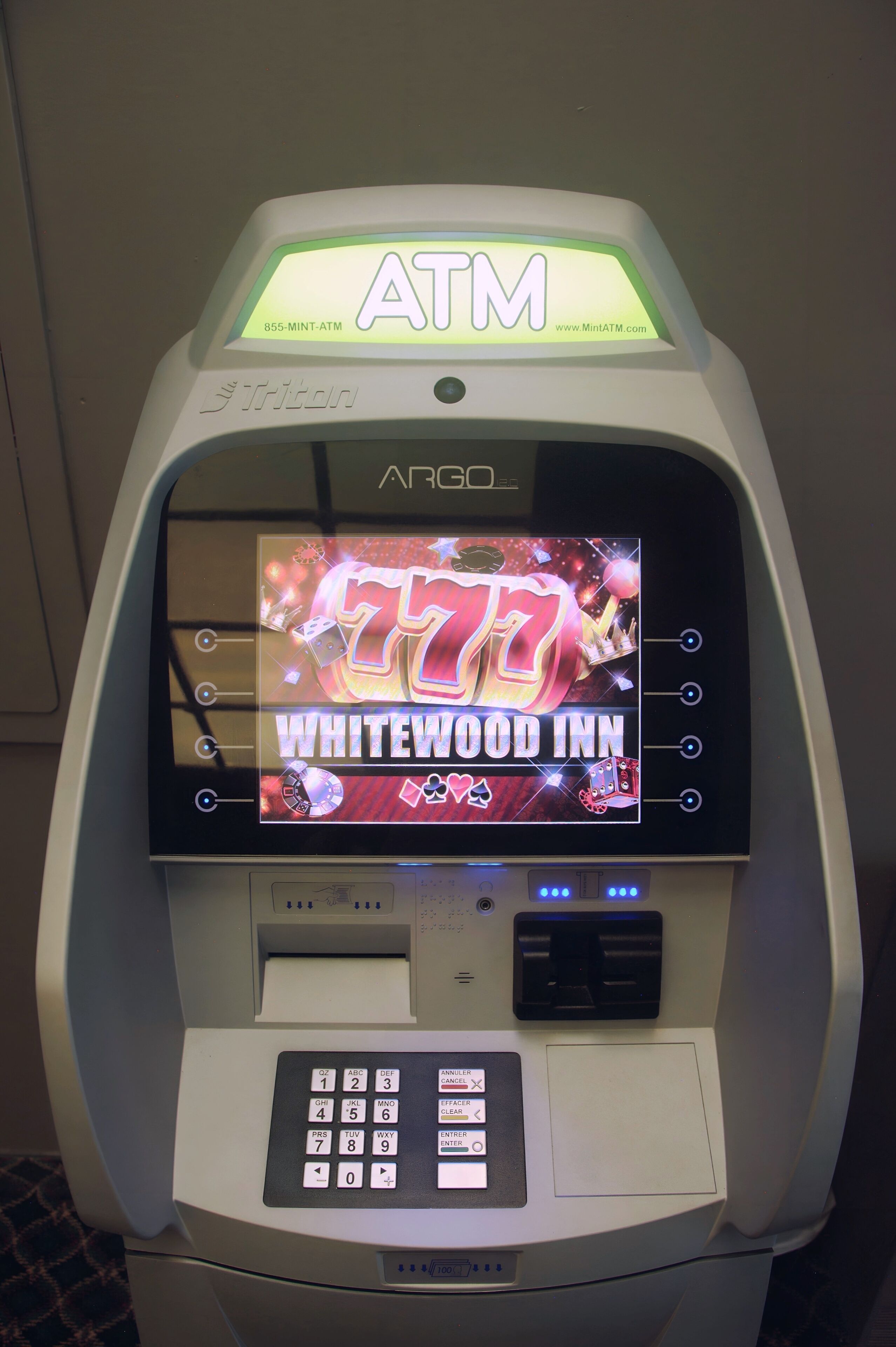 An ATM machine with a screen displaying the Whitewood Inn logo.